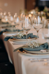 The table is set with elegant glasses for alcohol, napkins and tableware. Dinner service, catering, restaurant, formal dinner