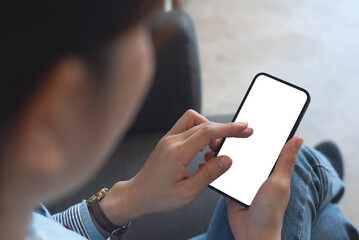 Mockup, woman's hands holding mobile phone with finger touching on blank screen. Woman using...