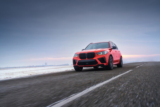 HELSINKI, FINLAND - MARCH 01, 2024: A red facelifted BMW X5 m Competition car is moving along the highway. A luxury SUV from a famous German brand.