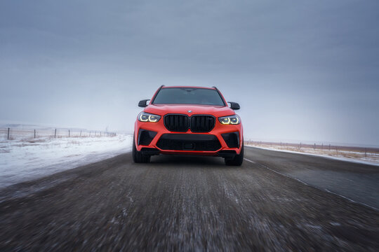 HELSINKI, FINLAND - MARCH 01, 2024: A red facelifted BMW X5 m Competition car is moving along the highway. A luxury SUV from a famous German brand.