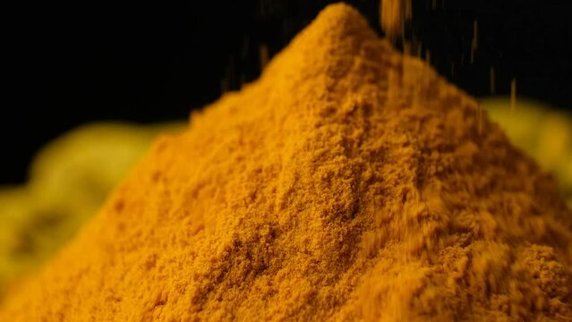Turmeric powder pouring, macro slow motion