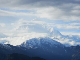 Majestic mountains adorned with clouds, creating a dramatic panorama that uplifts the soul and awakens the spirit.