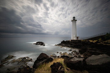 Le Phare du Vieux-Fort, white lighthouse on a cliff. Dramatic clouds overlooking the sea. Pure...