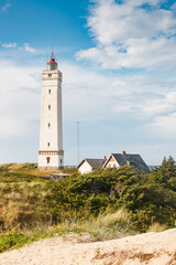Fototapeta na wymiar Lighthouse in the sand dunes on the beach of Blavand, Jutland Denmark Europe