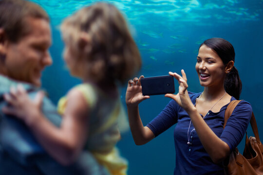 Aquarium, woman or phone for photo, family or outing for fun, happy or bonding together in Brazil. People, smartphone and fish tank for social media, exploration and marine life on playful weekend