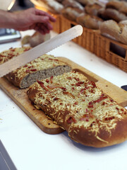 pizza de pan de barra  con queso y bacón recién sacada de horno