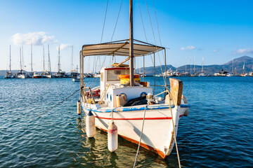Traditional Greek fishing boat on blue sea in Adamas port bay, Milos island, Cyclades, Greece - 749448989