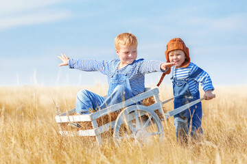 Children play planes in a field on a summer sunny day. - 749449901