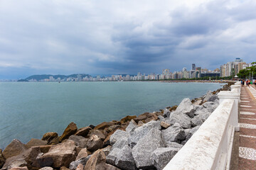Fototapeta na wymiar SANTOS, SP, BRAZIL - JANUARY 02, 2024: View of the city's beautiful waterfront with its historic wall separating the promenade.