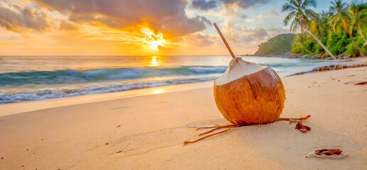 Noix de coco sur une plage déserte tropicale sans personne avec un coucher de soleil.