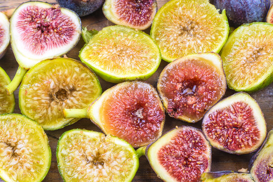 Background of ripe purple and yellow fig fruits; Close up for chipped halves of ripe juicy figs