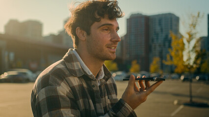 Caucasian man walking outside recording voicemail speakerphone handsome guy use virtual assistant...