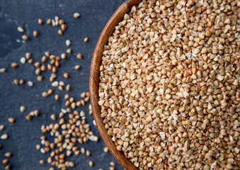 Organic Raw Buckwheat Groats in a Wooden Bowl. Healthy Eating Concept. Top View.