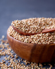 Organic Raw Buckwheat Groats in a Wooden Bowl. Healthy Eating Concept.