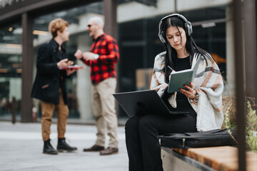 Entrepreneurs engage in a productive business meeting outdoors, using laptops and taking notes.