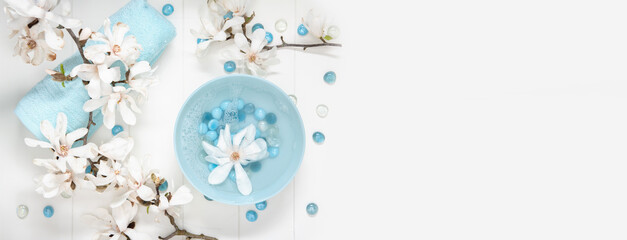 turquoise bowl with water and mother of pearl spa stones for gentle manicure in the salon with...