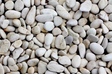 A pile of smooth, oval, matte, white, textured pebbles, perfect for a background