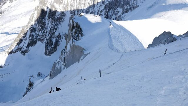 Steep snowy mountain peaks with skiers
