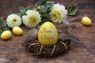 Frohe Ostern: Blumen mit Ostereiern in einem Nest. Das Osterei ist mit 