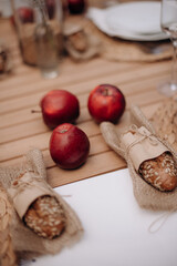 A set table at a banquet with food. Bread and apples on the table. Catering, service, aperitif. Celebration, event under the open sky outside