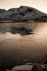 Frozen landscape, with yellow hue of winter sun, Sommaroy near Tromso, northern Norway