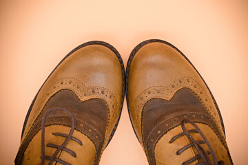 Photography of brown men shoes on an orange background