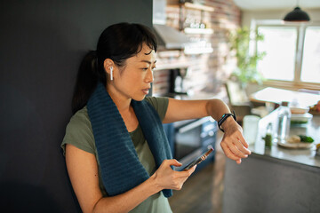 Asian woman checking fitness tracker after workout