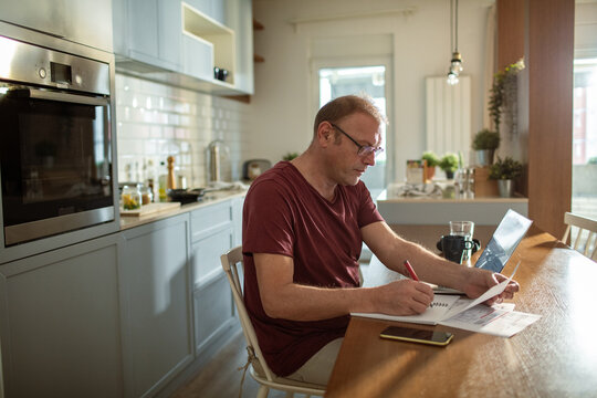 Stressed man going over bills at home