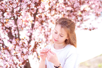 Smiling girl looking up to a blooming tree