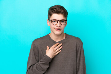 Teenager Russian man isolated on blue background pointing to oneself