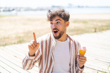 Handsome Arab man with a cornet ice cream at outdoors intending to realizes the solution while...