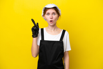 Young English fisherwoman isolated on yellow background intending to realizes the solution while lifting a finger up - obrazy, fototapety, plakaty
