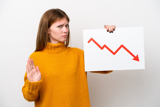 Young English woman isolated on white background holding a sign with a decreasing statistics arrow symbol and doing stop sign