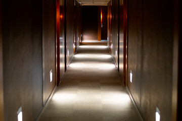 Hotel and building corridor in the dark with several lights with doors  - obrazy, fototapety, plakaty