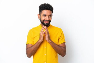 Young Brazilian man isolated on white background scheming something