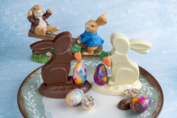 Milk and white chocolate bunnies next to small chocolate eggs_1.