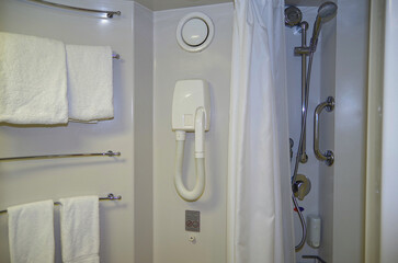 Modern design bathroom with sink, shower, towels and mirror and mosaic tiles in cabin or stateroom...