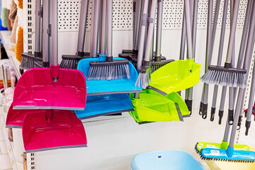 dustpans and brooms for cleaning rooms and offices on the counter in a supermarket