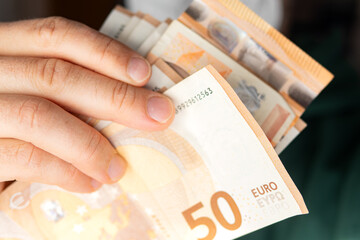 Close-Up of Hands Holding Fifty Euro Banknotes
