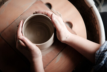 Top view of unrecognizable Ceramics Maker working with Pottery Wheel in Cozy Workshop Makes a Future Vase or Mug, Creative People Handcraft Pottery Class