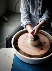Unrecognizable Ceramics Maker working with Pottery Wheel in Cozy Workshop Makes a Future Vase or...