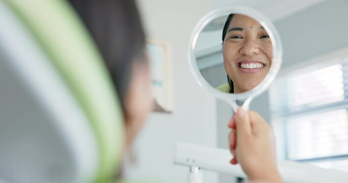Dental, smile and happy woman with mirror check at a dentist for teeth whitening results. Mouth, oral care and Asian female client with tooth, cleaning or routine checkup in Tokyo with satisfaction