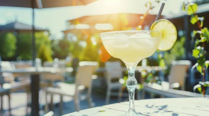 Tuinposter Citrus cocktail on restaurant patio table, warm summer sunlight © Kondor83