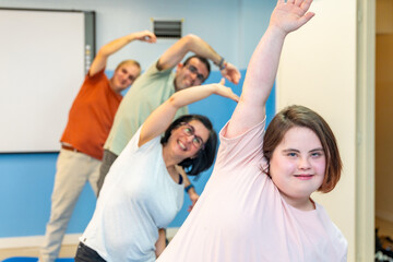 Group of people with special needs stretching in the gym