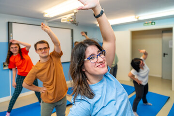 Happy people with special needs exercising in a gym