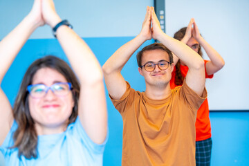 Disabled people raising arms practicing yoga in the gym