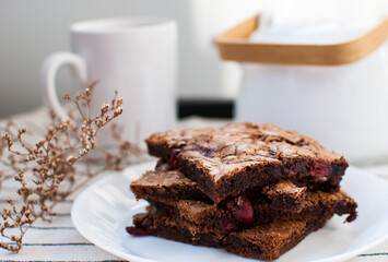 A little stacks of tasty sweet brownie with cherry on light background.