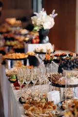 Food, a beautifully decorated catering banquet table with a variety of appetizers with cheese, ham, prosciutto and fruit. At a corporate, Christmas, birthday or wedding celebration. Buffet table. Buff