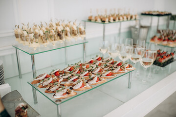 Food, a beautifully decorated catering banquet table with a variety of appetizers with cheese, ham, prosciutto and fruit. At a corporate, Christmas, birthday or wedding celebration. Buffet table. Buff