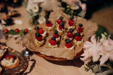Food, a beautifully decorated catering banquet table with a variety of appetizers with cheese, ham, prosciutto and fruit. At a corporate, Christmas, birthday or wedding celebration. Buffet table. Buff